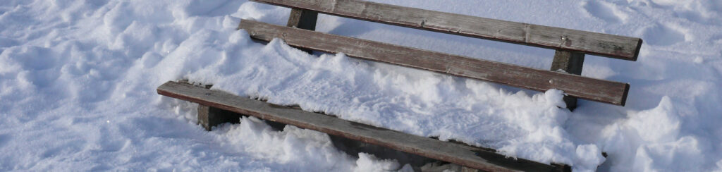 Holzbank mit viel Schnee